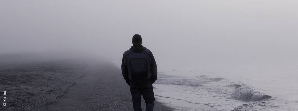 samotny mężczyzna spacerujący po plaży